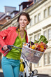 © ZoomTeam - Pretty young woman with bicycle and groceries in old town street