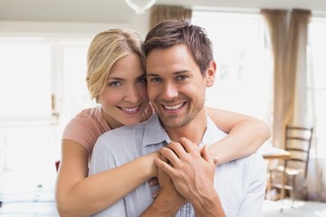 Wall Mural - Woman embracing man from behind at home