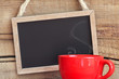 Framed vintage blackboard with a red cup of steamy coffee
