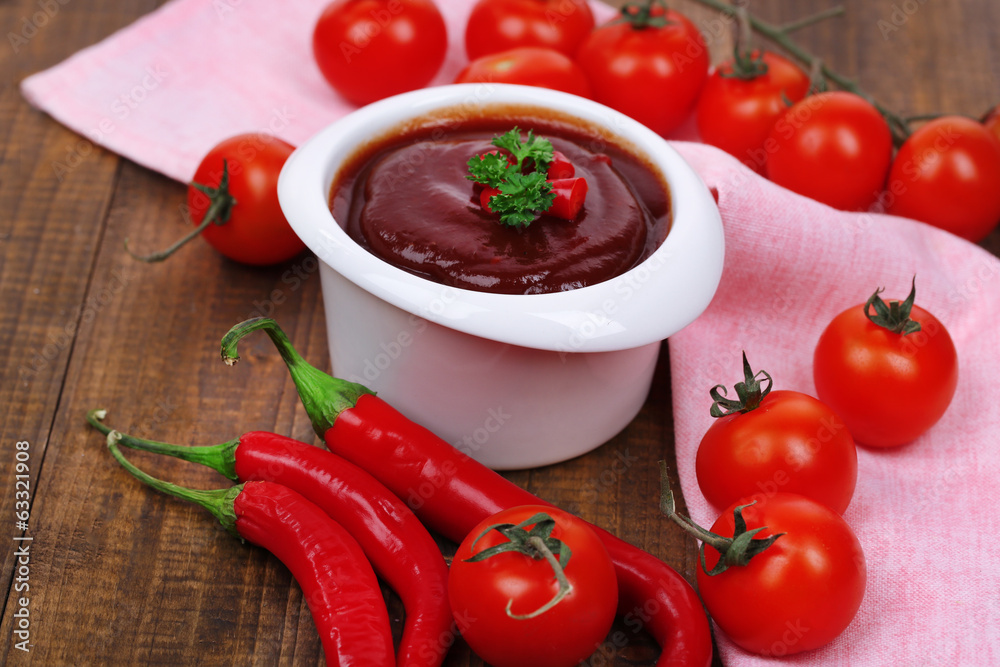 Tomato sauce in bowl on wooden table close-up