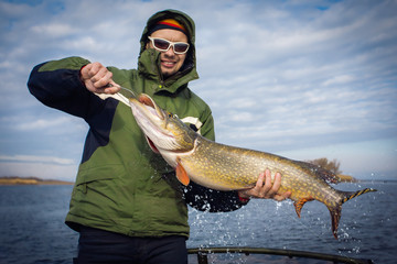 Wall Mural - Happy angler with pike fishing trophy