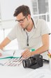 © WavebreakMediaMicro - Concentrate male artist sitting at desk with photos