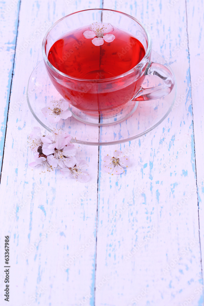 Fragrant tea with flowers on wooden table close-up