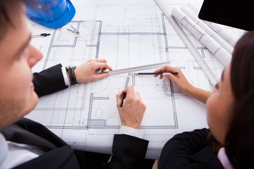 Poster - Architects Working On Blueprint At Desk