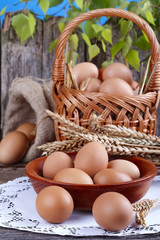 Eggs in wooden bowl with a little basket and linen sack 