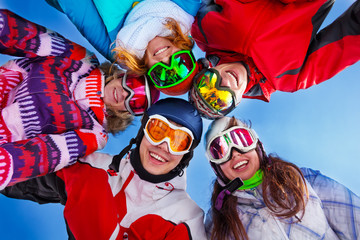 Five happy friends standing with goggles