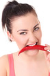 Beautiful woman with chili pepper in mouth.