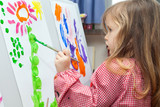 Fototapeta Sypialnia - Little girl painting on paper