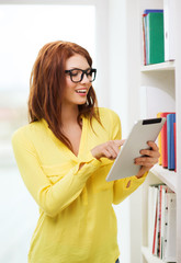 Wall Mural - smiling female student with tablet pc in library