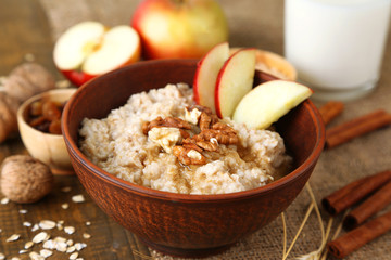 Poster - Tasty oatmeal with nuts and apples on wooden table