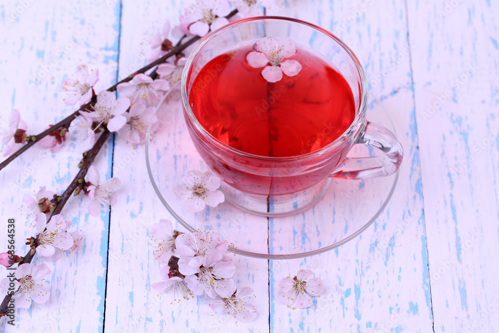 Fragrant tea with flowering branches on wooden table close-up