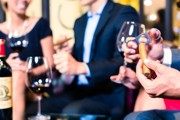 Asian man cutting cigar in restaurant