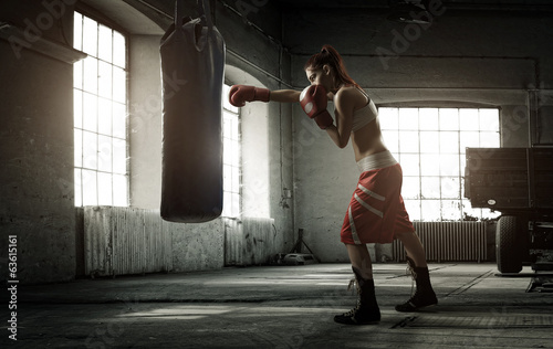 Naklejka na drzwi Young woman boxing workout in an old building