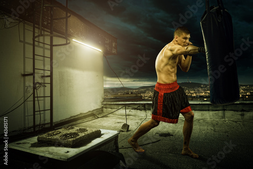 Εκτύπωση καμβά Young man boxing training , on top of the house above the city