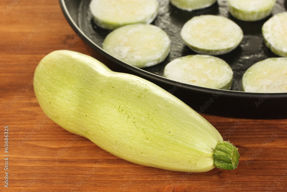 sliced squash in a pan on wooden table close-up