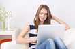 © Africa Studio - Young woman resting with laptop on sofa at home