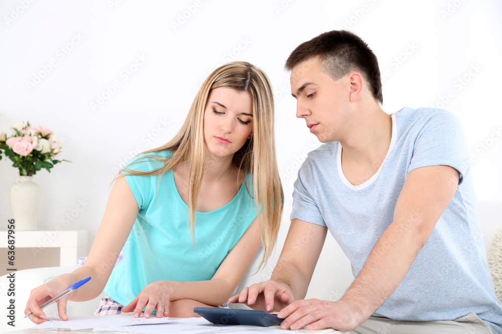 Young couple calculating finance at desk,