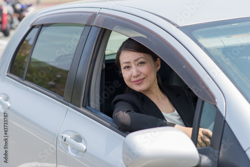 車を運転するアジアのスーツの女性 Buy This Stock Photo And