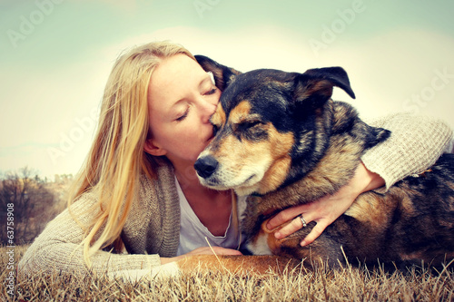 Fotografía Woman Tenderly Hugging and Kissing Pet Dog