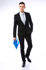 Canvas Print - Studio shot of a businessman with blue folder on gray background