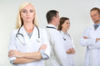 © Africa Studio - Doctor standing in front of coworkers on grey background
