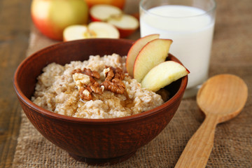 Canvas Print - Tasty oatmeal with nuts and apples on wooden table