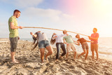 Fototapeta  - Friends Dancing Limbo at Beach