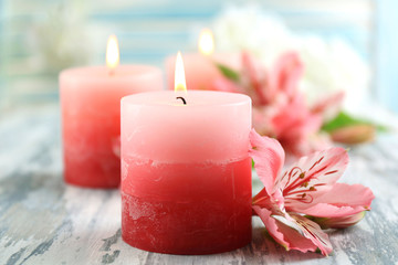 Sticker - Beautiful candles with flowers on wooden background