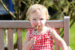 Funny toddler girl in eating meat from bbq in summer garde