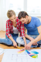 smiling couple looking at color samples at home