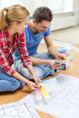 smiling couple looking at color samples at home