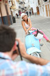© goodluz - Man taking picture of girlfriend sitting on moto