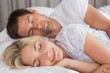 © lightwavemedia - Couple lying in bed with eyes closed