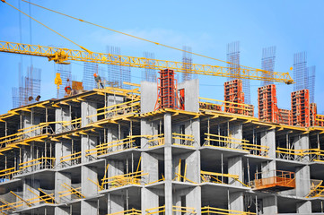 Crane and building construction site against blue sky