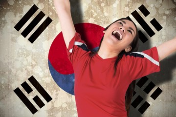 Wall Mural - Composite image of excited asian football fan cheering