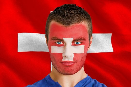 Composite image of serious young swiss fan with facepaint