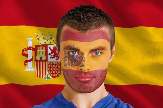 Composite image of serious young spain fan with facepaint