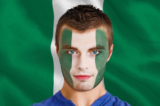 Composite image of serious young nigeria fan with facepaint