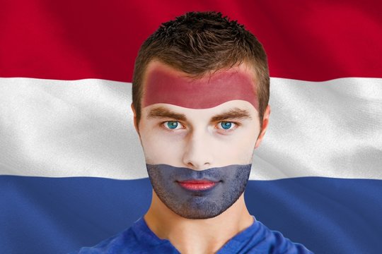 Composite image of serious young netherlands fan with facepaint