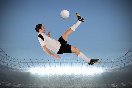 Composite image of football player in white kicking