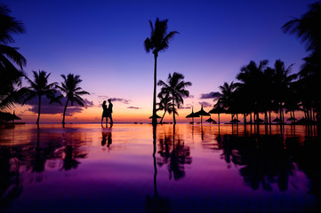 Wall Mural - Silhouettes of young couple at scenic sunset