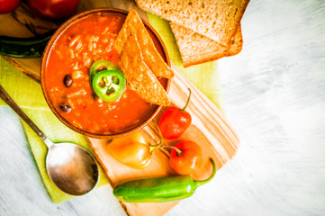 Canvas Print - Hot and spicy fresh made Mexican chili soup on rustic background