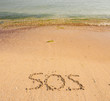 S.O.S written in the sand