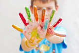 Niño con manos pintados de colores