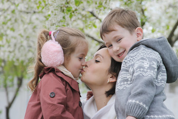 Two children hugging their mother