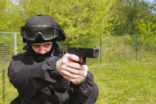 Fotografía officer in tactical helmet pointing a gun