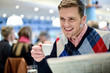 Smiling man reading newspaper at restaurant