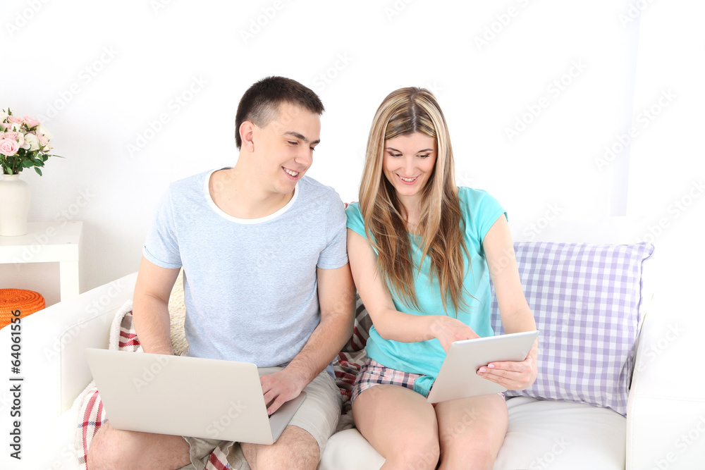 Loving couple  relaxing with laptop  and tablet,
