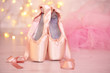 Ballet pointe shoes on floor on bokeh background