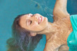 Relaxed woman on back in swimming pool